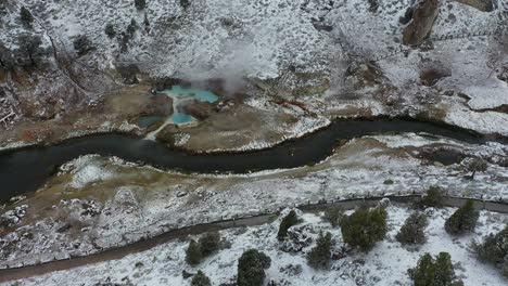 hot springs in winter landscape, steam from geothermal water and creek, mammoth lakes, california usa, drone shot