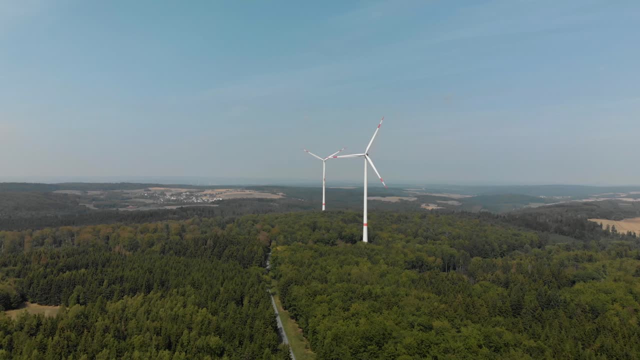 toma aérea amplia si un parque eólico en el campo alemán, turbinas girando en un día soleado y brillante