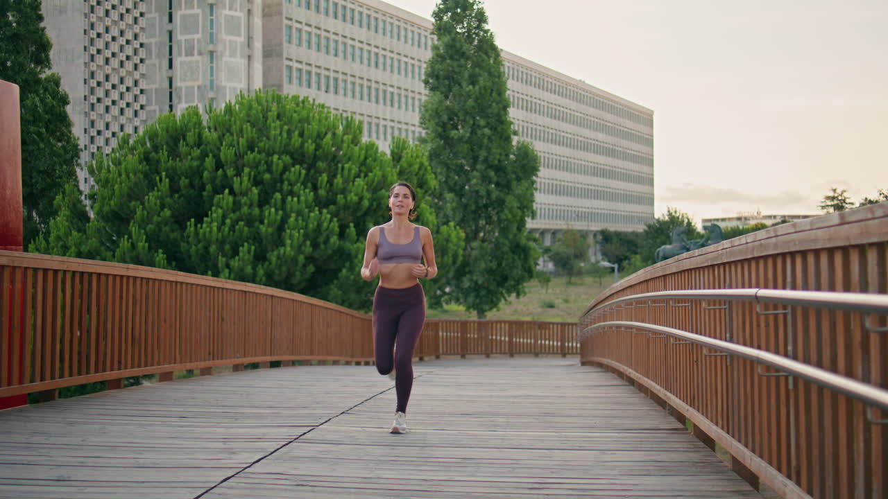 Active jogger running urban park. Satisfied athletic woman doing cardio training