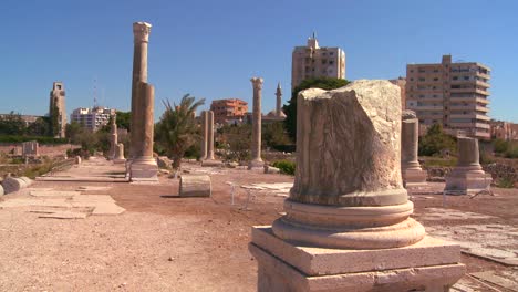 Las-Ruinas-Romanas-De-Neumático-Con-El-Fondo-De-La-Ciudad-Moderna