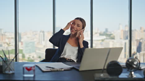 mujer de negocios alegre llamando al teléfono móvil en la ventana panorámica.
