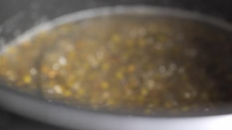 primer plano de frijol mungo o bubur kacang hijau cocinado y revuelto con una cuchara de madera