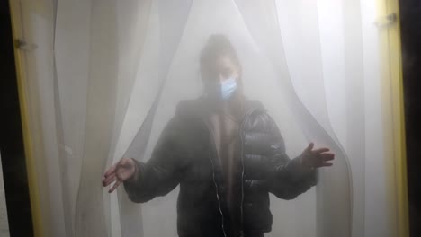 mujer con una máscara en una puerta llena de niebla