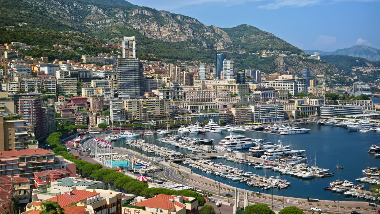 View of boats docked in the in the Monaco Marina with the skyline of the city on the background