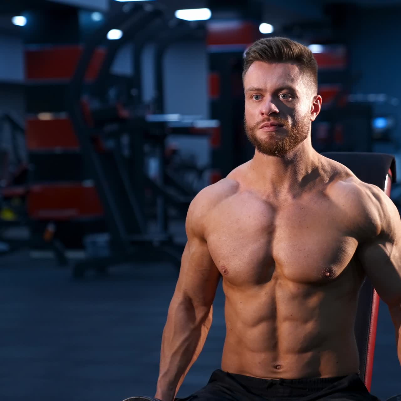 Fit young man lifting dumbbells doing workout at a gym. Sport, fitness, weightlifting, bodybuilding, training, athlete, workout exercises concept. Slow motion