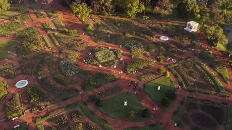 toma aérea en órbita que muestra a muchas personas descansando y caminando en el parque rosedal en buenos aires - hermoso