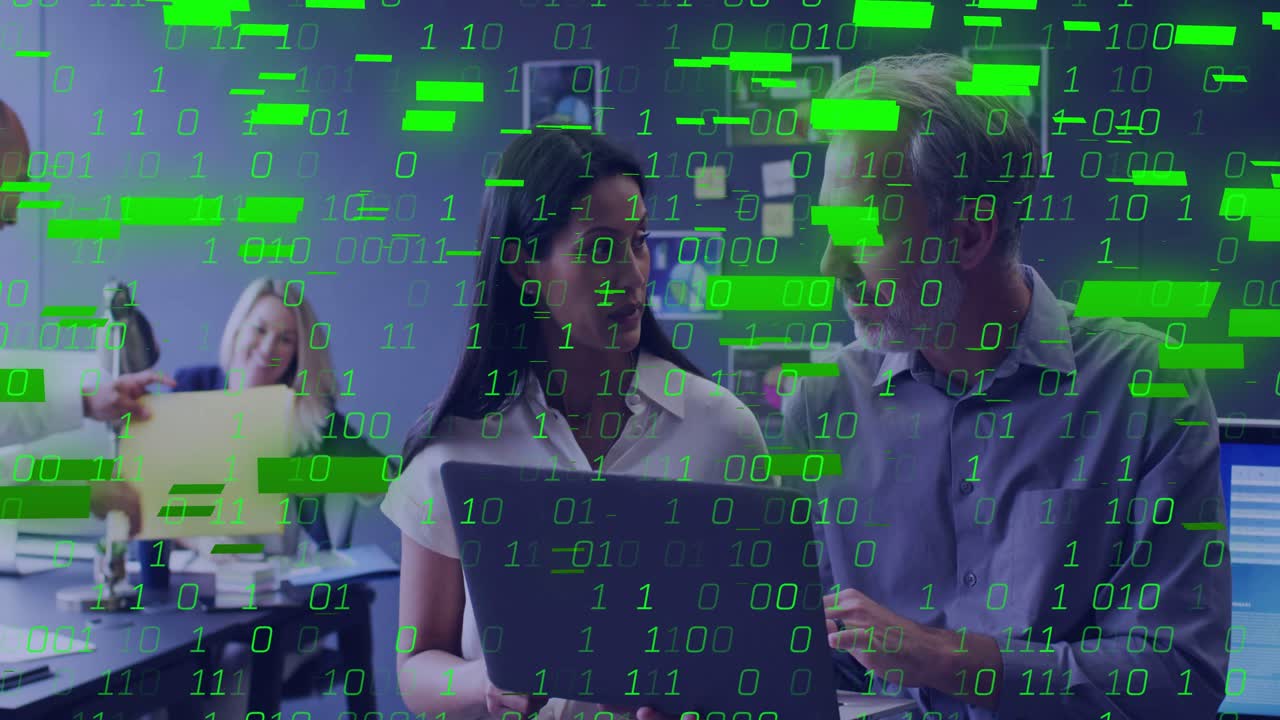 Two coworkers holding laptop, pointing, causing green binary overlay while team reviewing files