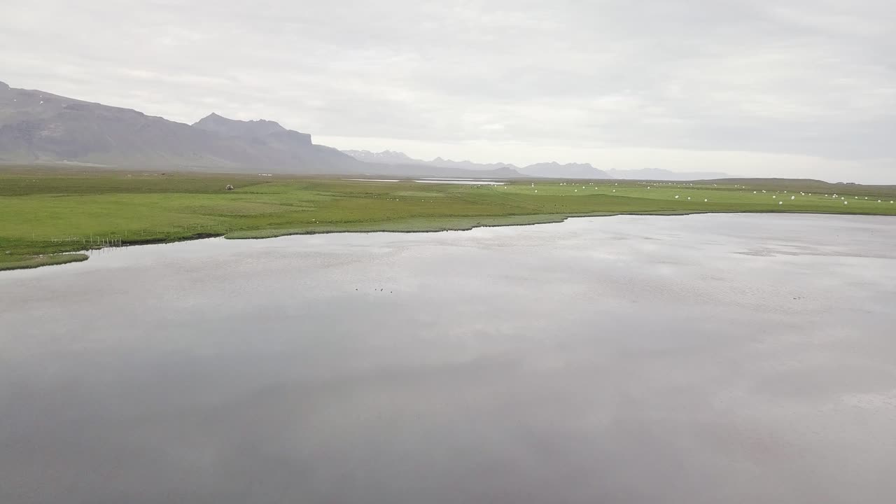 아이슬란드 스나이펠스니스 반도에서 흐린 여름 동안 잔잔한 호수의 항공 영상