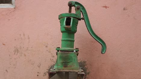 green antique water spigot stands stationary