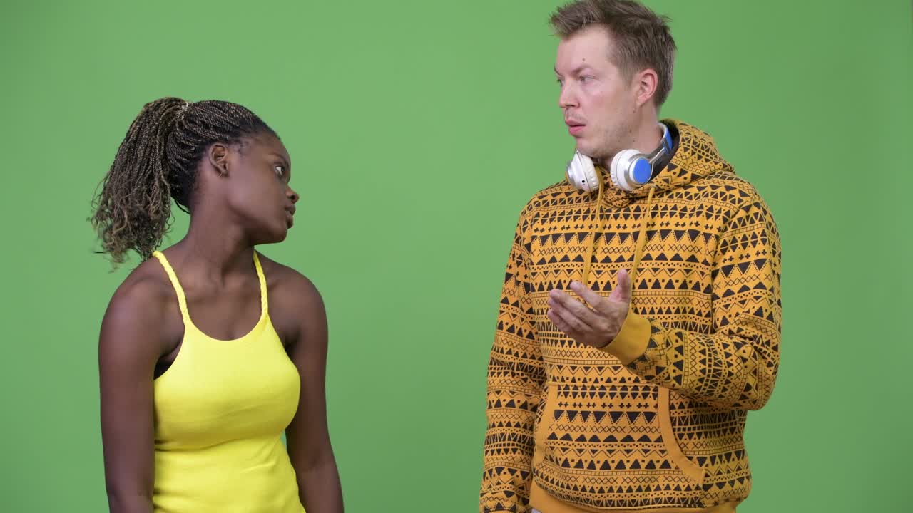 Young multi-ethnic couple giving thumbs down together