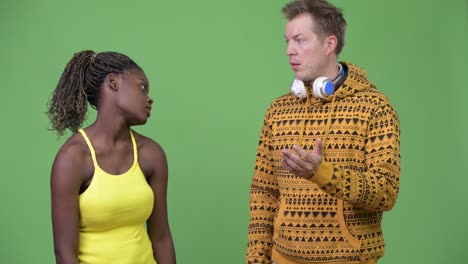 young multi-ethnic couple giving thumbs down together