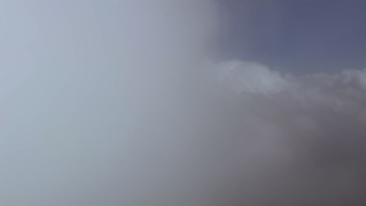 Immersive pilot’s perspective flying through white storm clouds in a deep blue sky. ultra-realistic 4K shot