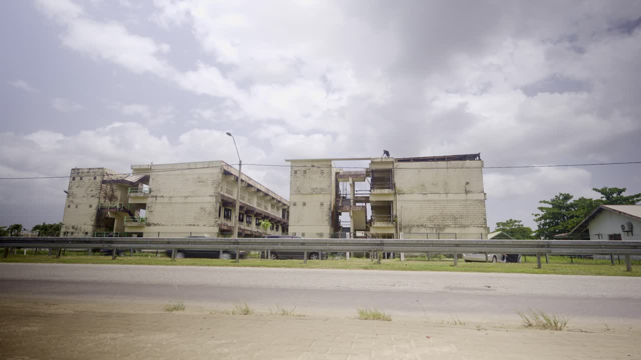 Wide street view of Natin building in Paramaribo Suriname with cars passing by