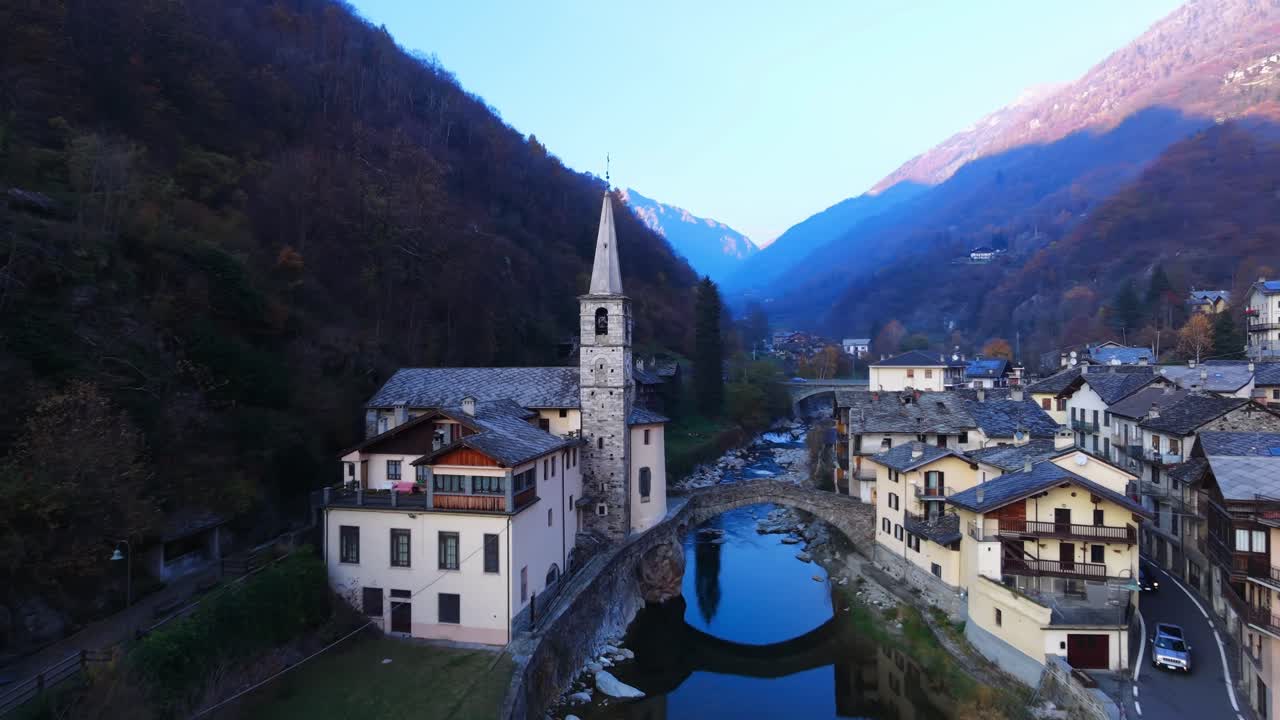 Villaggio di Fontainemore con un fiume, un ponte, una chiesa e case tradizionali in Valle d'Aosta. Vista aerea.