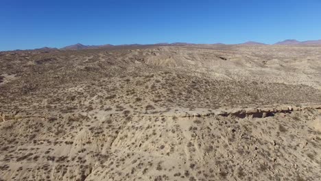 an aerial over a beautiful dry cliff face in the remote mojave desert of california or nevada 1