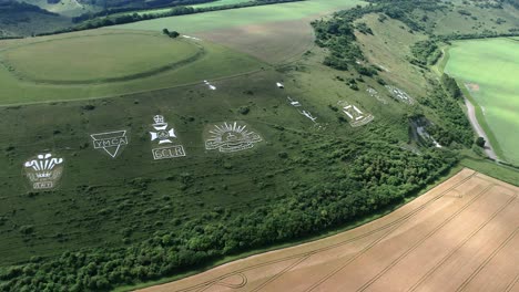 Fovant-set-of-regimental-badges-carved-into-chalk-hillside-aerial-view-orbiting-the-historical-monument