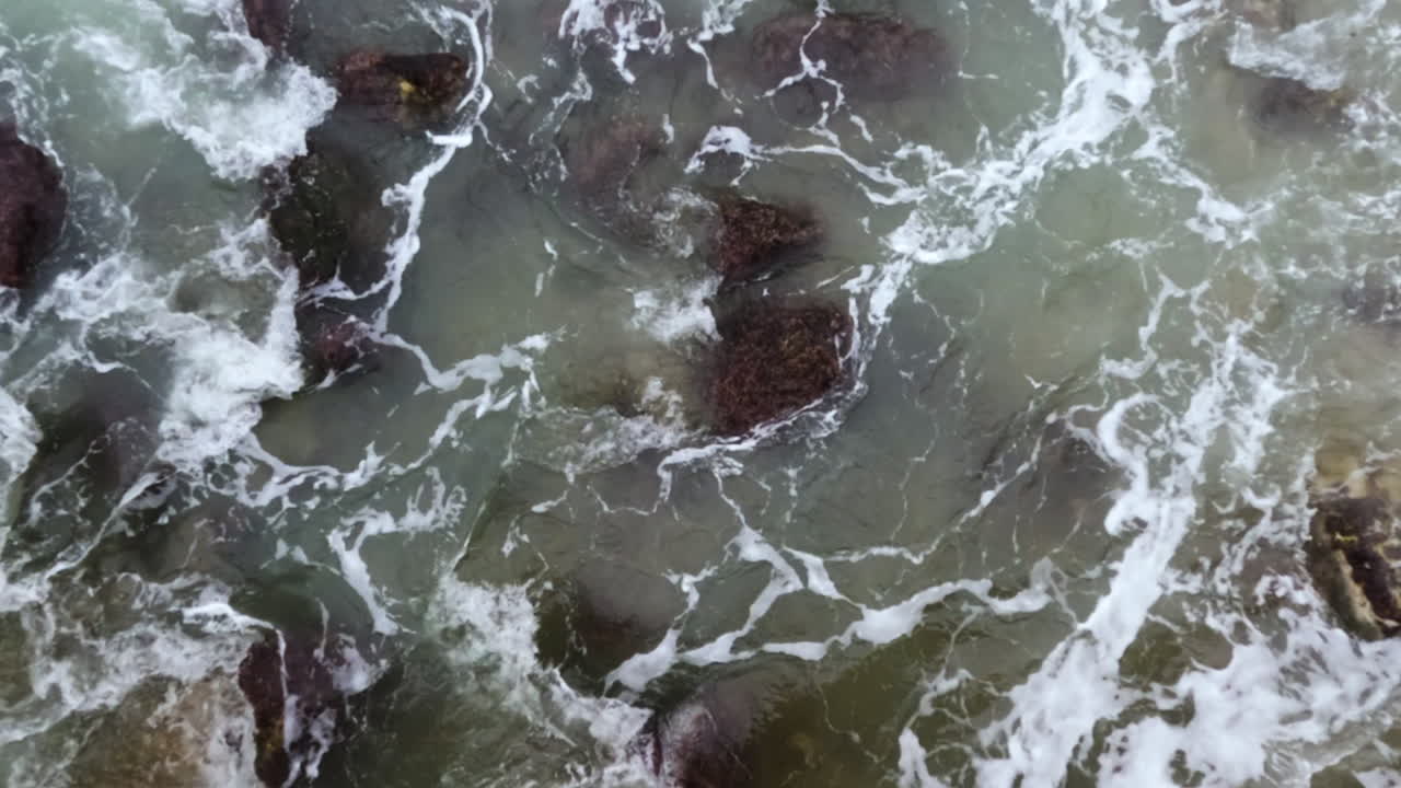 Slow motion shot of ocean water streaming through rocks