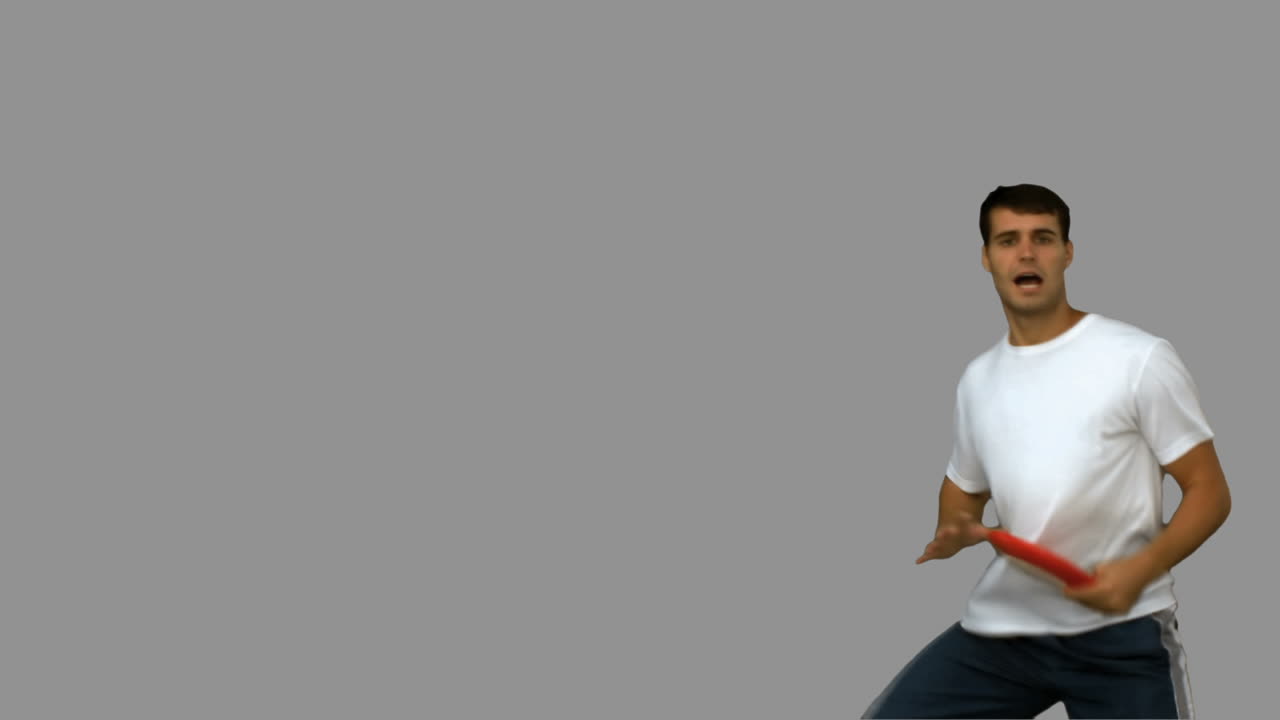 hombre saltando y atrapando un frisbee en la pantalla gris