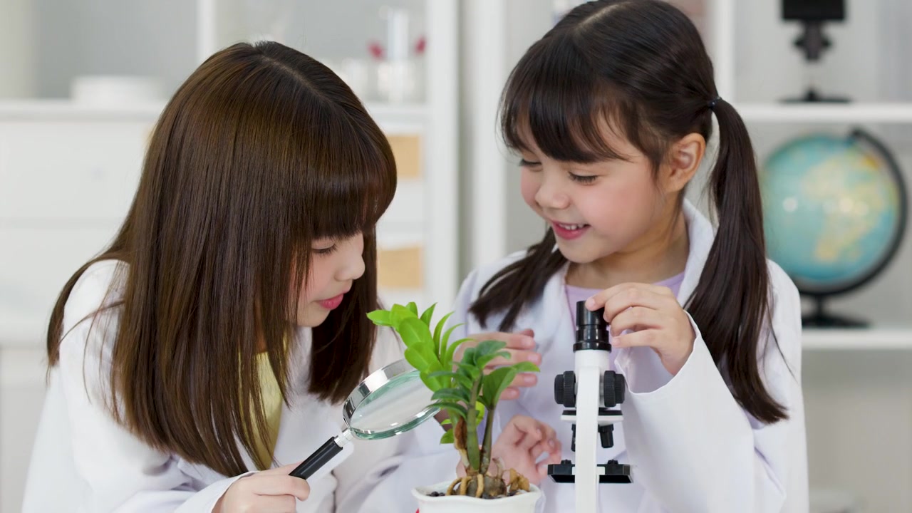 教室で科学ツールを使って生物学の実験を行う、白衣を着た2人の若い学生