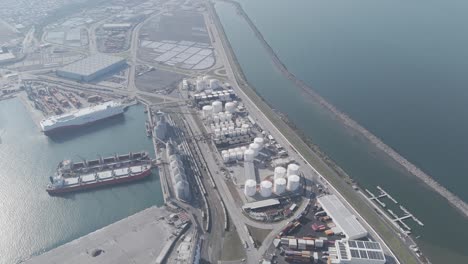 aerial view of a petrochemical terminal by the ocean, with vessels docked nearby. a snapshot of maritime industry and energy infrastructure.