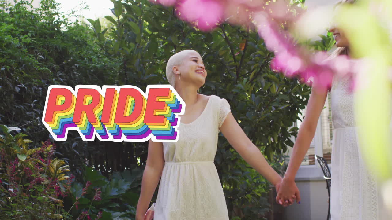 Animation of rainbow pride text over diverse female married couple holding hands