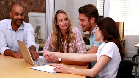 Casual-business-team-having-a-meeting-using-laptop