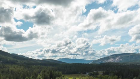 cumulus clouds rolling over sunny sky of forest and mountains