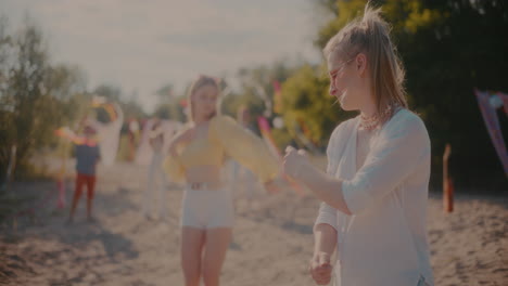 mujer joven bailando cerca de amigos grooving a la música en la playa