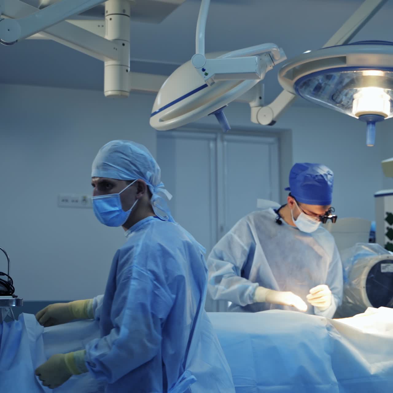 Surgeons in modern operating room. Group of doctors in medical uniform working in the operating theater. Surgical equipment in the hospital.