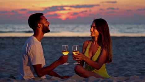 couple enjoying wine at sunset on the beach