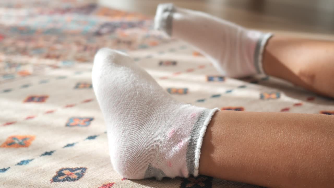 pies de niño con calcetines en la alfombra