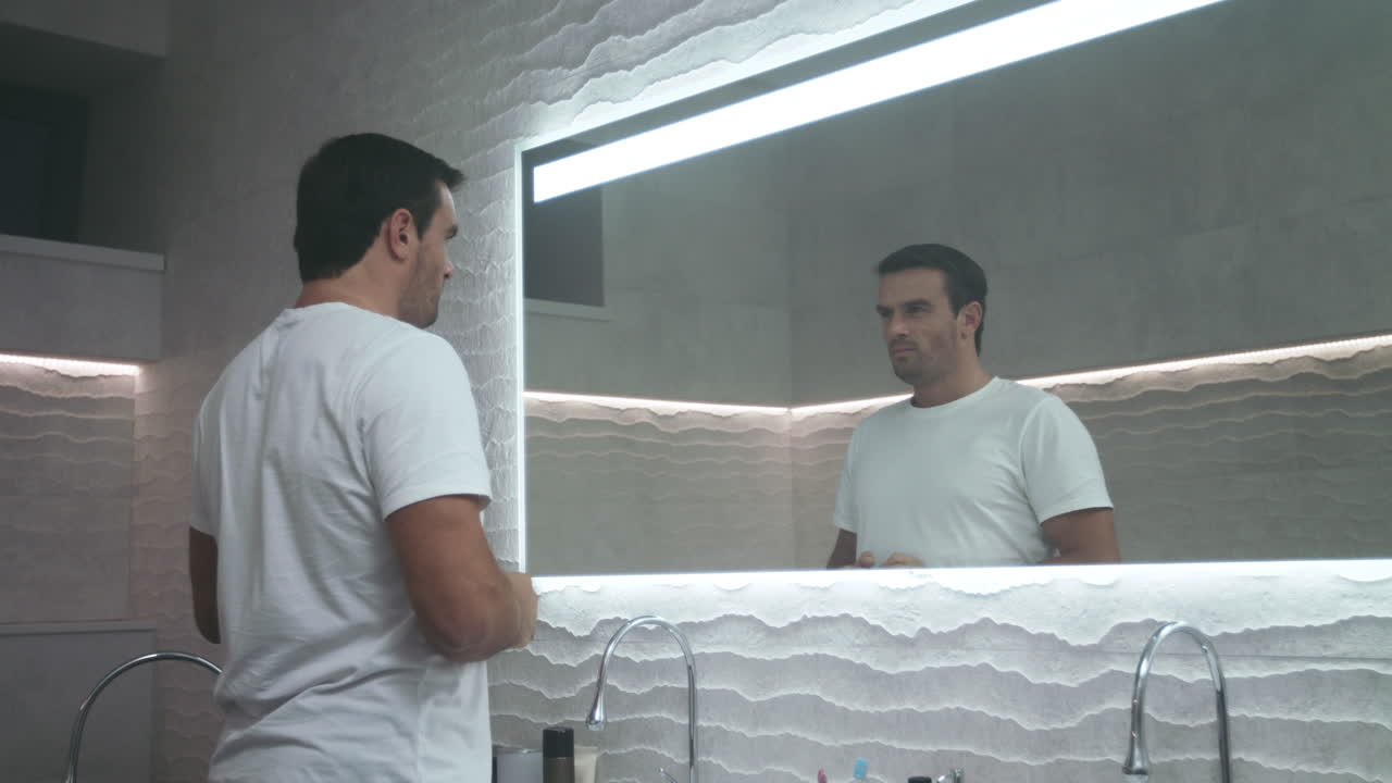 Uomo affascinante che si motiva in bagno. Ritratto di uomo automotivato.
