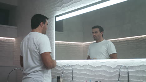 handsome man motivating himself in bathroom. portrait of self motivation man.