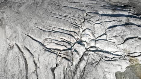 Aerial flyover over a glacier near Arolla in Valais, Switzerland with a spinning panning view from the glacier ice towards the sunlit Val d&#039;Herens valley
