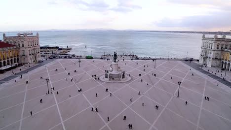 wide view of people walking around in praça do comércio, terreiro do paço, right by the tagus river, in the center of lisbon, portugal