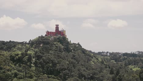 iconic palace of pena on top of forestry mountain in portugal, handheld view