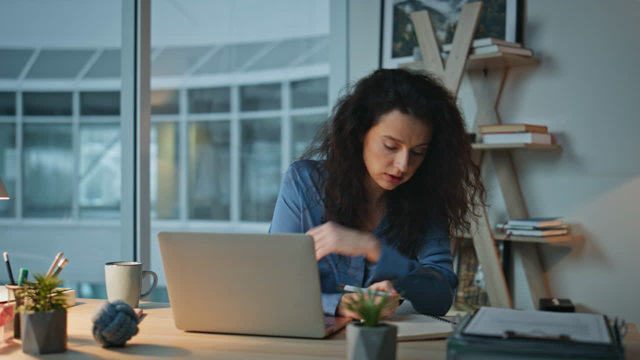 Businesswoman reviewing laptop information making notes. Closeup late manager