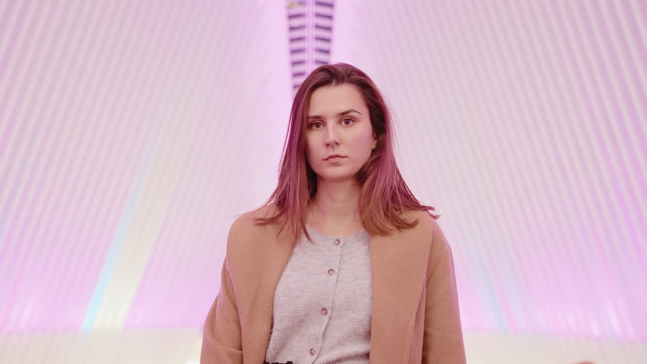 Woman in a beige coat in a modern building