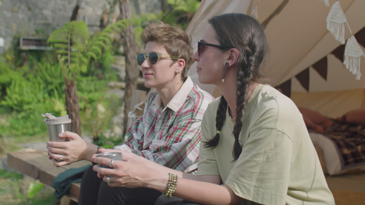 Female Tourists Having Tea at Glamping and Discussing Nature