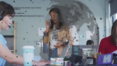 animación de un globo giratorio contra una mujer de negocios afroamericana hablando en teléfono inteligente en la oficina
