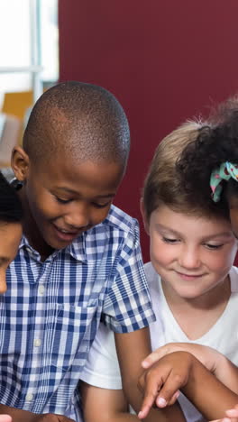 animation of pencils over diverse schoolchildren using tablet and smiling