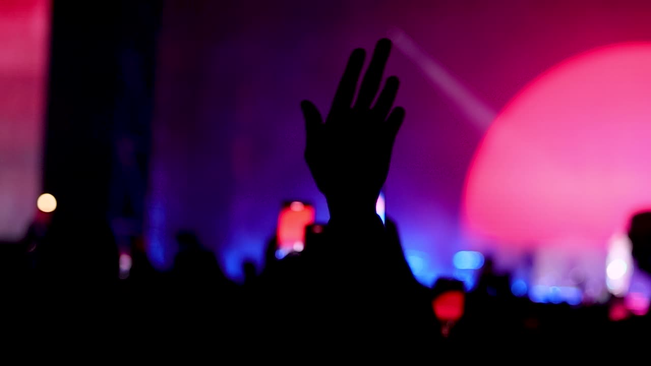 Fan che agita la mano davanti al palco