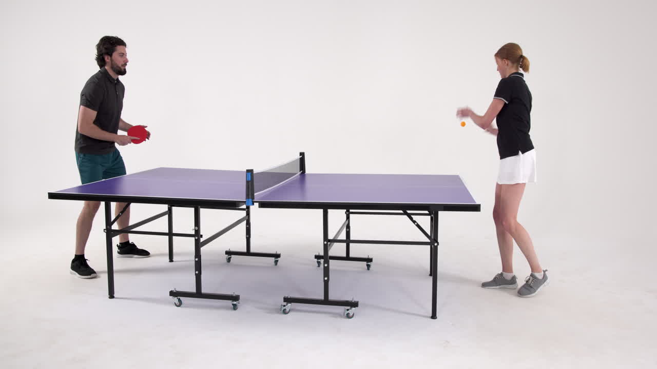 Playing table tennis, man and woman competing in friendly match indoors