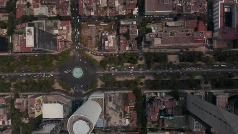 Vista-Aérea-De-Arriba-Hacia-Abajo-Del-Tráfico-Pesado-En-Las-Calles-De-La-Ciudad.-Cámara-De-Drones-Siguiendo-La-Calle-De-Varios-Carriles-Avenida-Paseo-De-La-Reforma-Entre-Edificios-Altos.-Ciudad-De-México,-México.