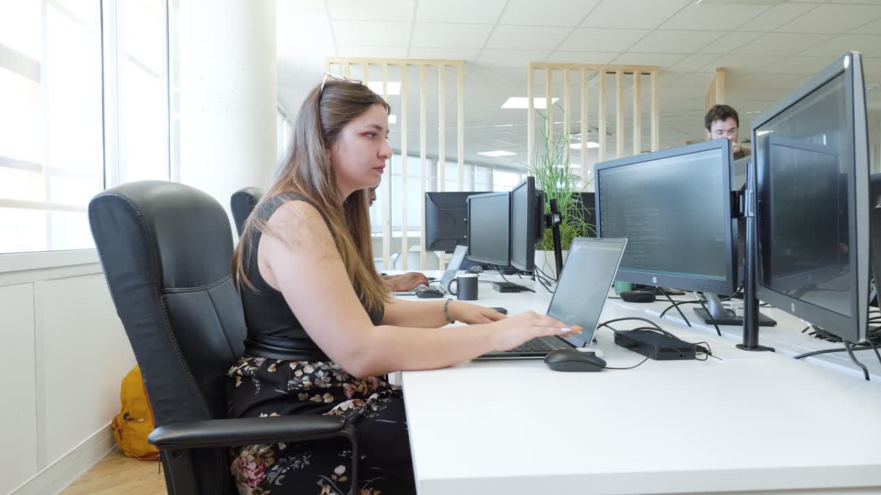 mujer trabajando en una computadora portátil en una oficina moderna