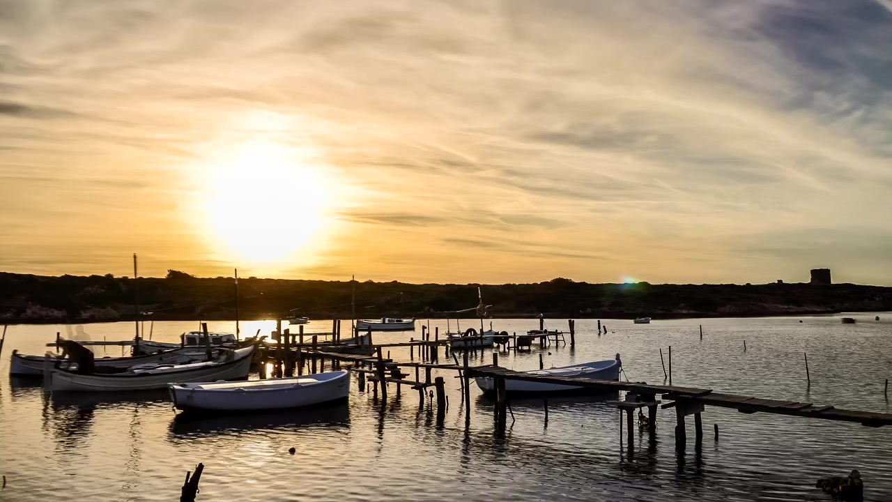 Sanitja port Menorca time lapse golden sunrise boats rocking with person departing pier on a voyage