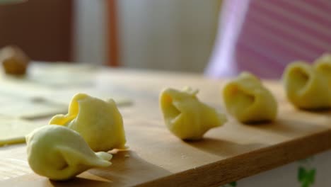 Close-up-of-dough-and-meatball-filling-popular-food-dish,-Polish-'Little-Ears'-Uszka-Dumplings-and-Pierogi---Traditional-Polish-Cuisine---Grandmother-old-hands-working-dough---Working-in-the-kitchen