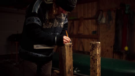 farm worker measuring and marking lumber wood with pencil and ruler