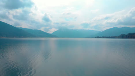 flying forwards over the tegernsee while ascending, wallberg covered in clouds