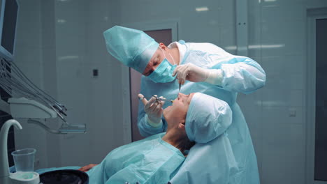 dentist operating oral cavity of patient. dental hygienist in operation with patient